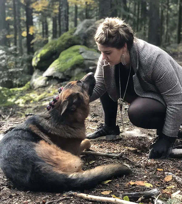 4650_600x670 marianne comportementaliste caressant un chien berger allemand dans une forêt. Le chien la regarde, oreilles baissées